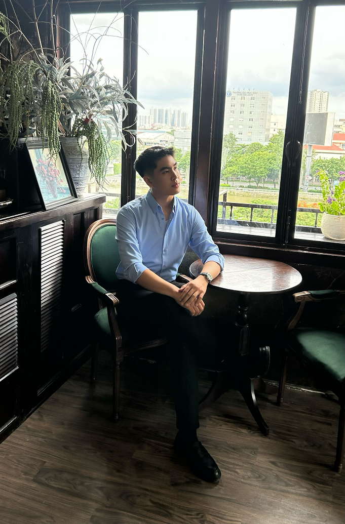 Một người đàn ông lịch lãm ngồi bắt chéo chân, để lộ đôi giày tây da được đánh bóng cẩn thận