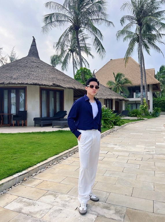 Một chàng trai lịch lãm mặc áo polo xanh navy và quần chinos màu be