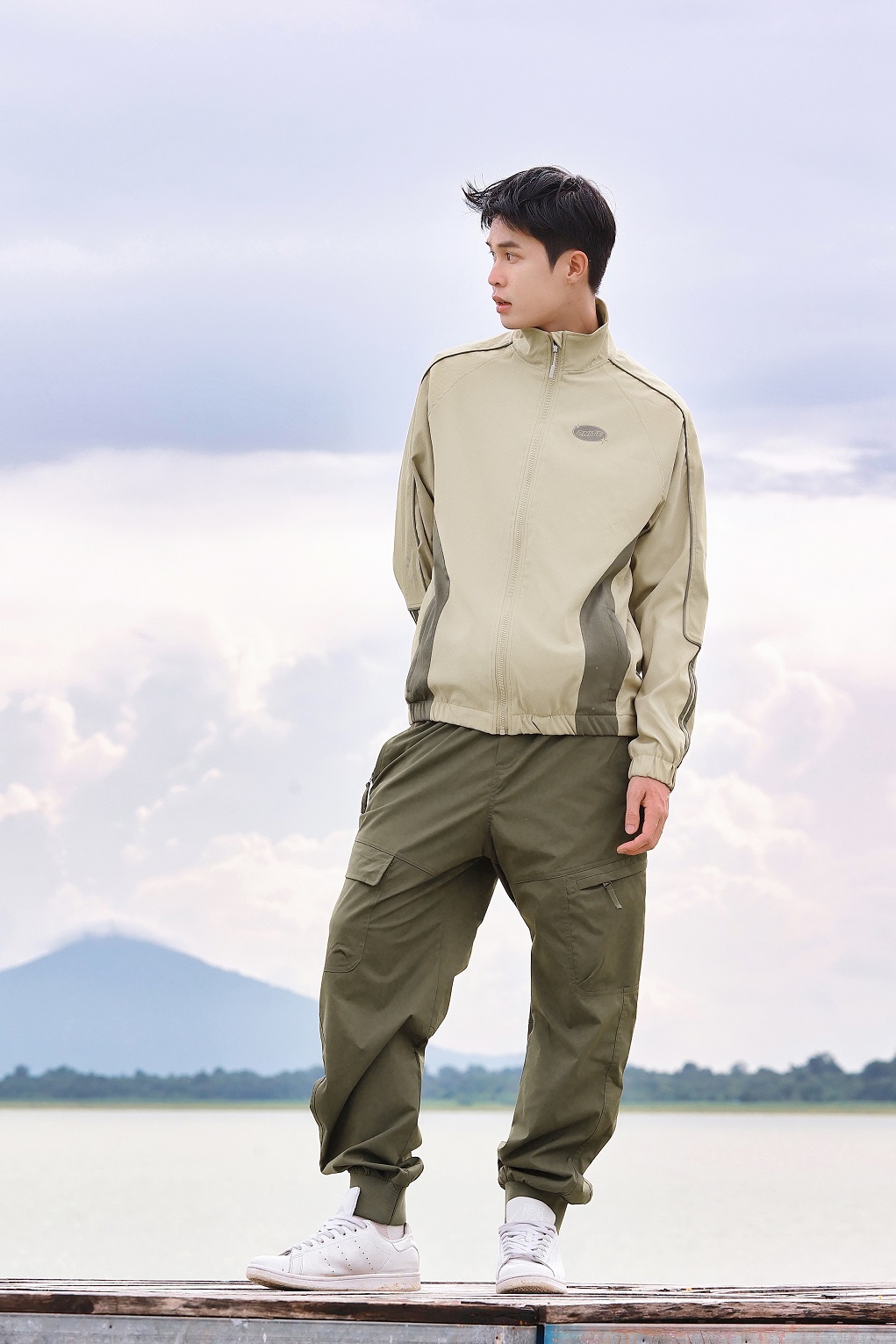 Một bộ trang phục layering sử dụng các màu trung tính như xám, đen và có điểm nhấn là áo sơ mi màu xanh olive