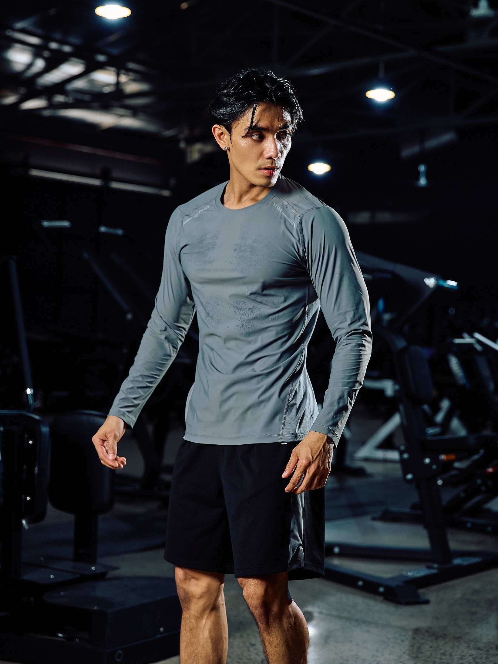 Một chàng trai vạm vỡ đang tự tin kiểm tra lại bộ trang phục tôn dáng của mình trước gương